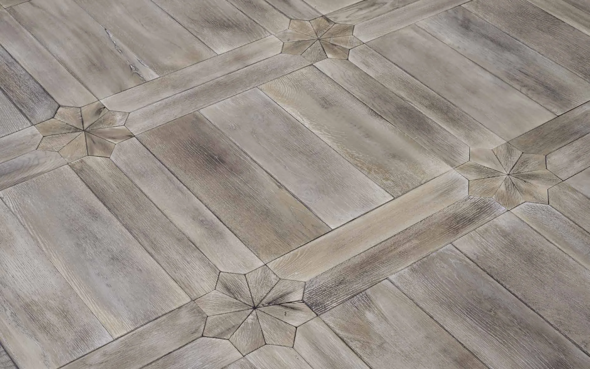 Revestimiento de piso de madera con patrones geométricos y detalles en esquinas con forma de estrella.