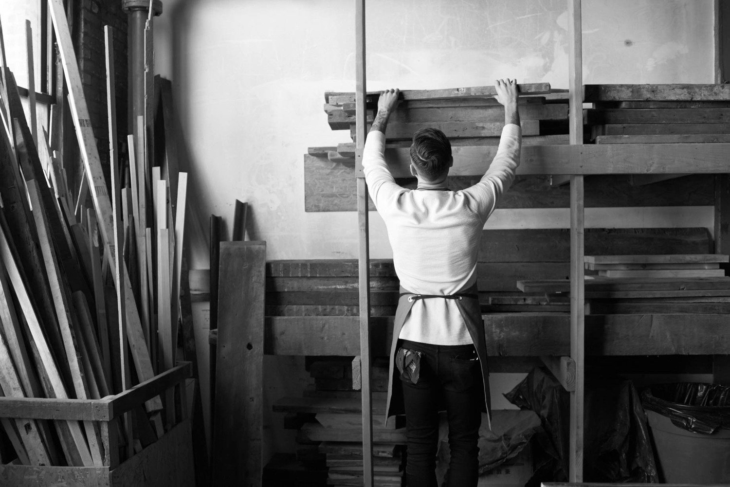 Hombre colocando madera en una estructura de un taller de carpintería