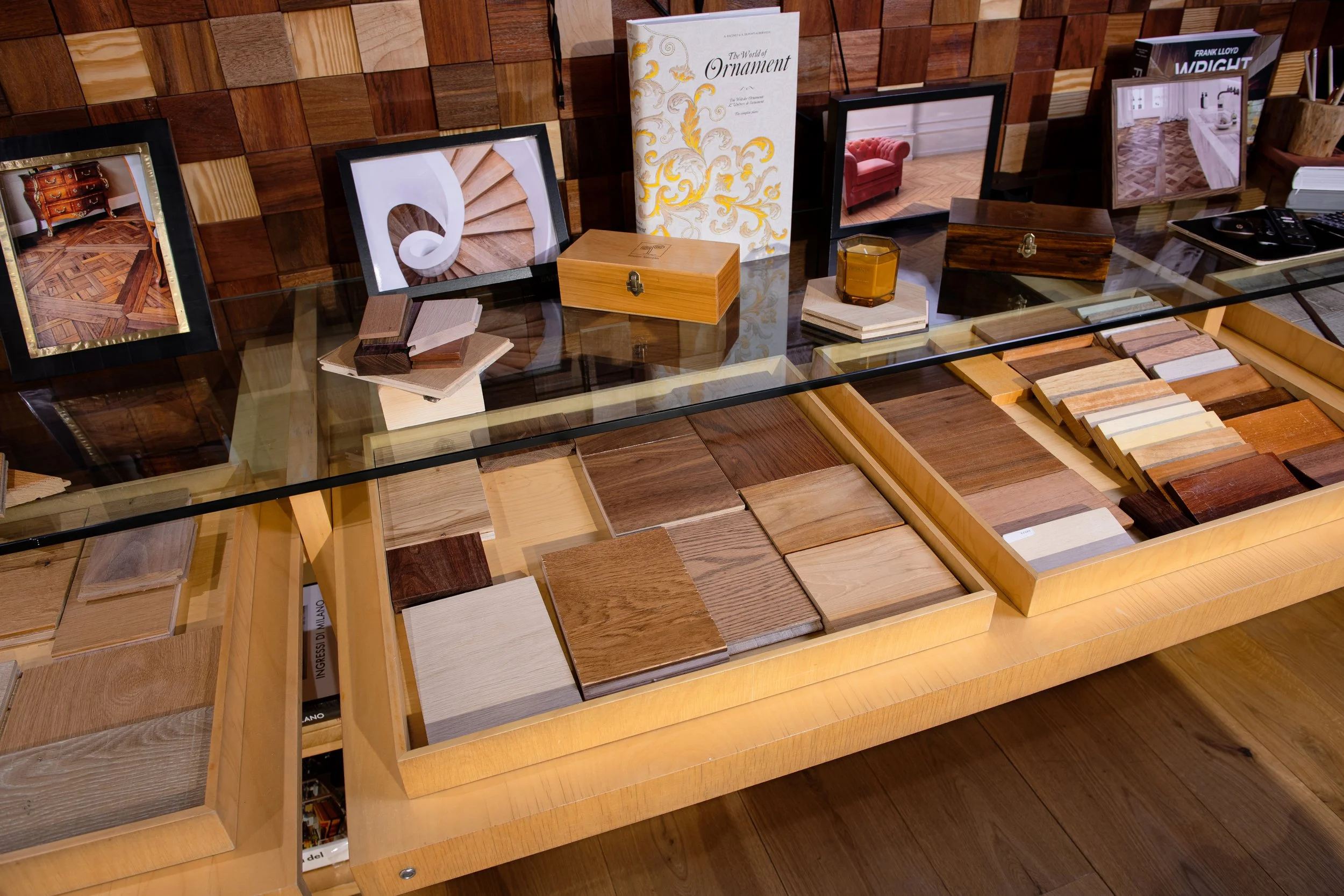 Muestras de diferentes tipos de madera y detalles decorativos en una mesa de exposición.