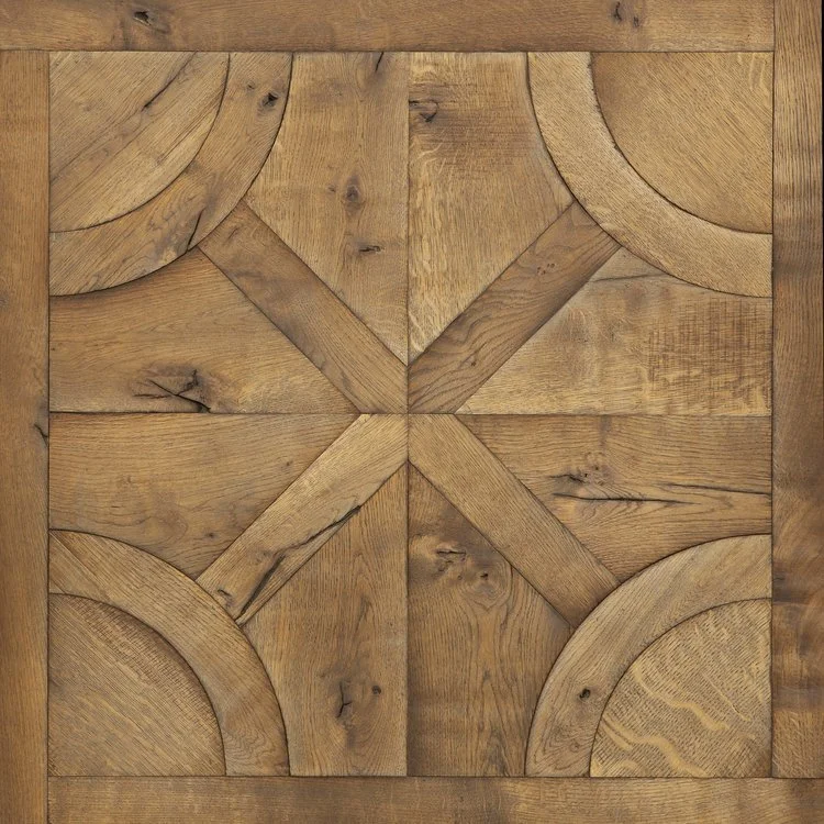 Superficie de madera con un patrón geométrico elaborado con diferentes piezas de madera talladas y unidas.