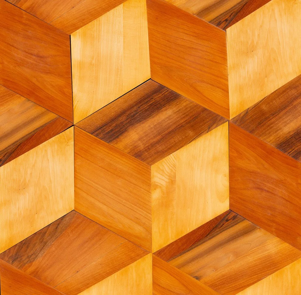 Muestras de cubos de madera con diferentes tonos naturales y vetas visible en un patrón de colocación.