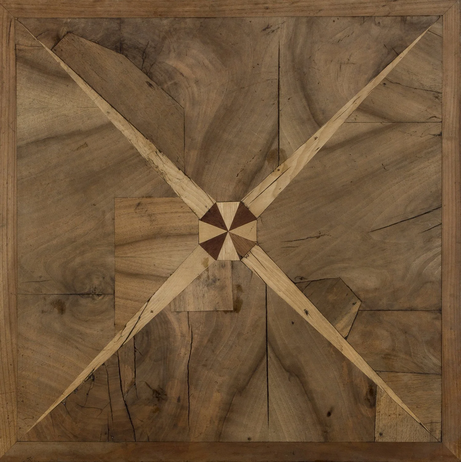 Mosaico de madera con un patrón de cuatro flechas entrelazadas en el centro.