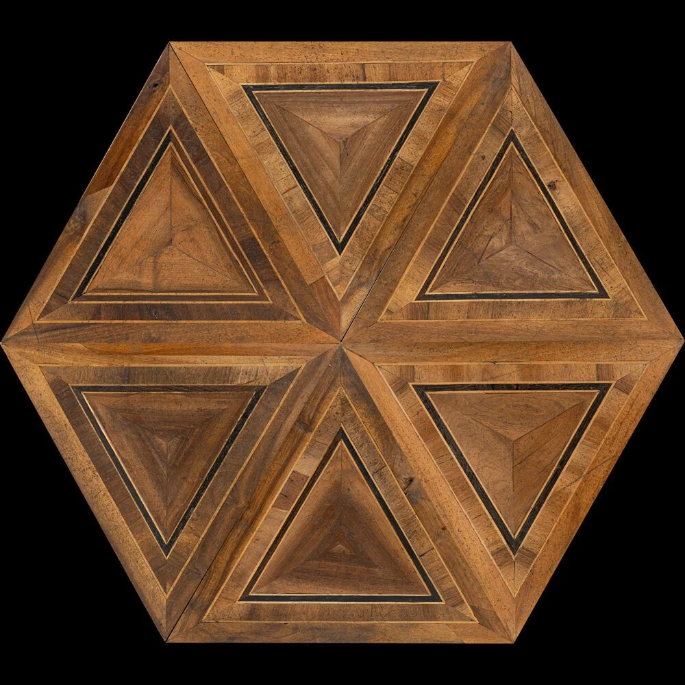 Imagen de un dado de madera de forma hexagonal con patrones en forma de triángulos en cada cara, sobre fondo negro.