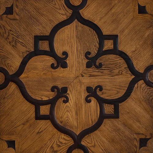 Diseño de madera en el piso con patrones geométricos y remates decorativos en negro.