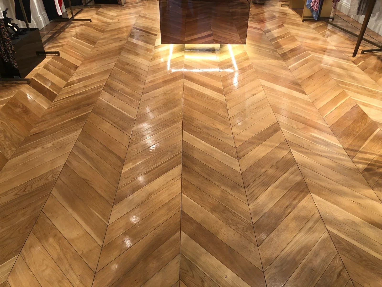 Suelo de madera en patrón de espiga en una tienda de ropa.