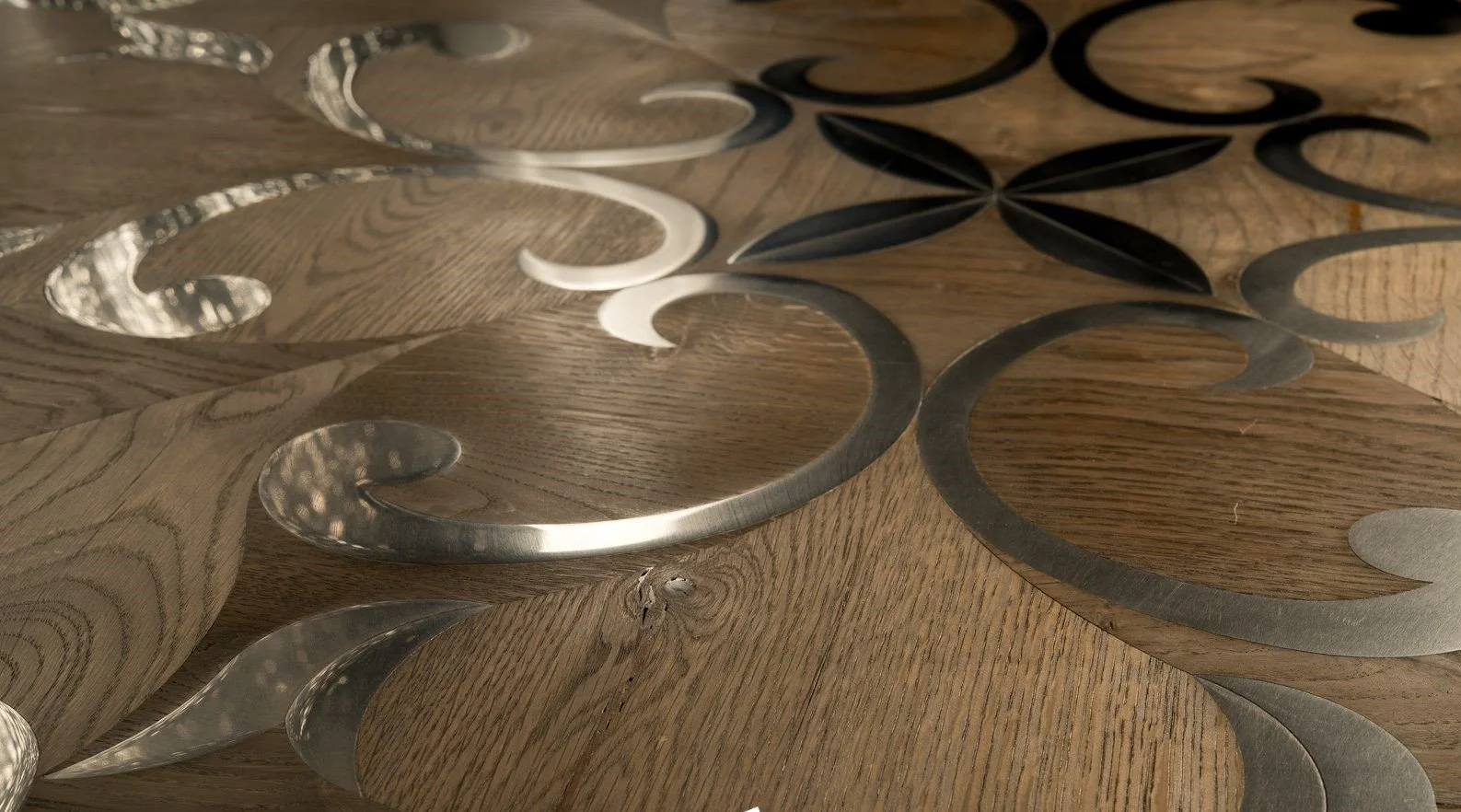 Decoración de madera y metal en forma de patrones abstractos en una superficie de madera.