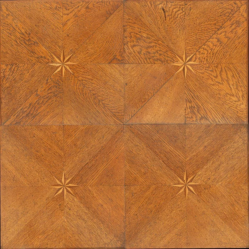 Suelo de madera con diseño en rombos y estrellas en las esquinas de cada módulo.