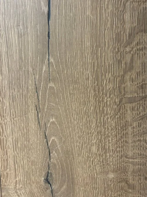 Superficie de madera con una grieta visible en el centro.