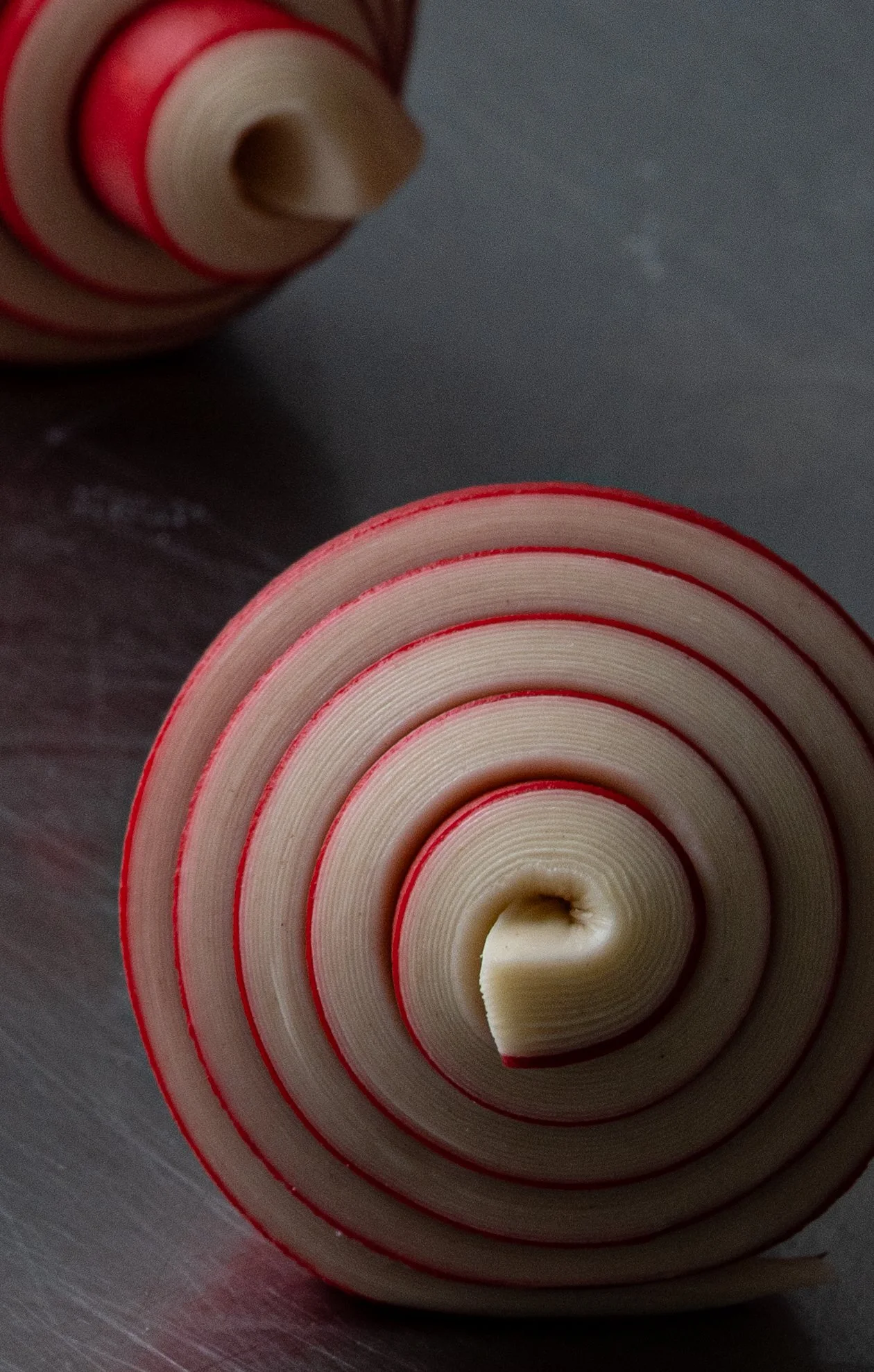 Croissant bicolor rojo recién enrollado