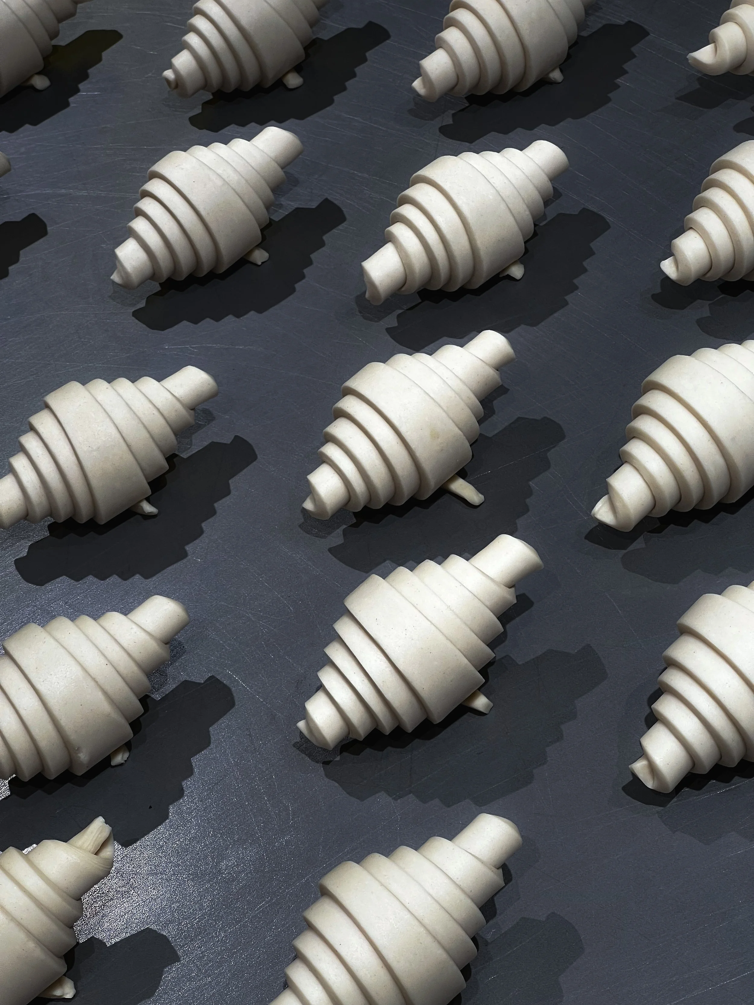 Croissant formados en crudo, colocados sobre una bandeja negra