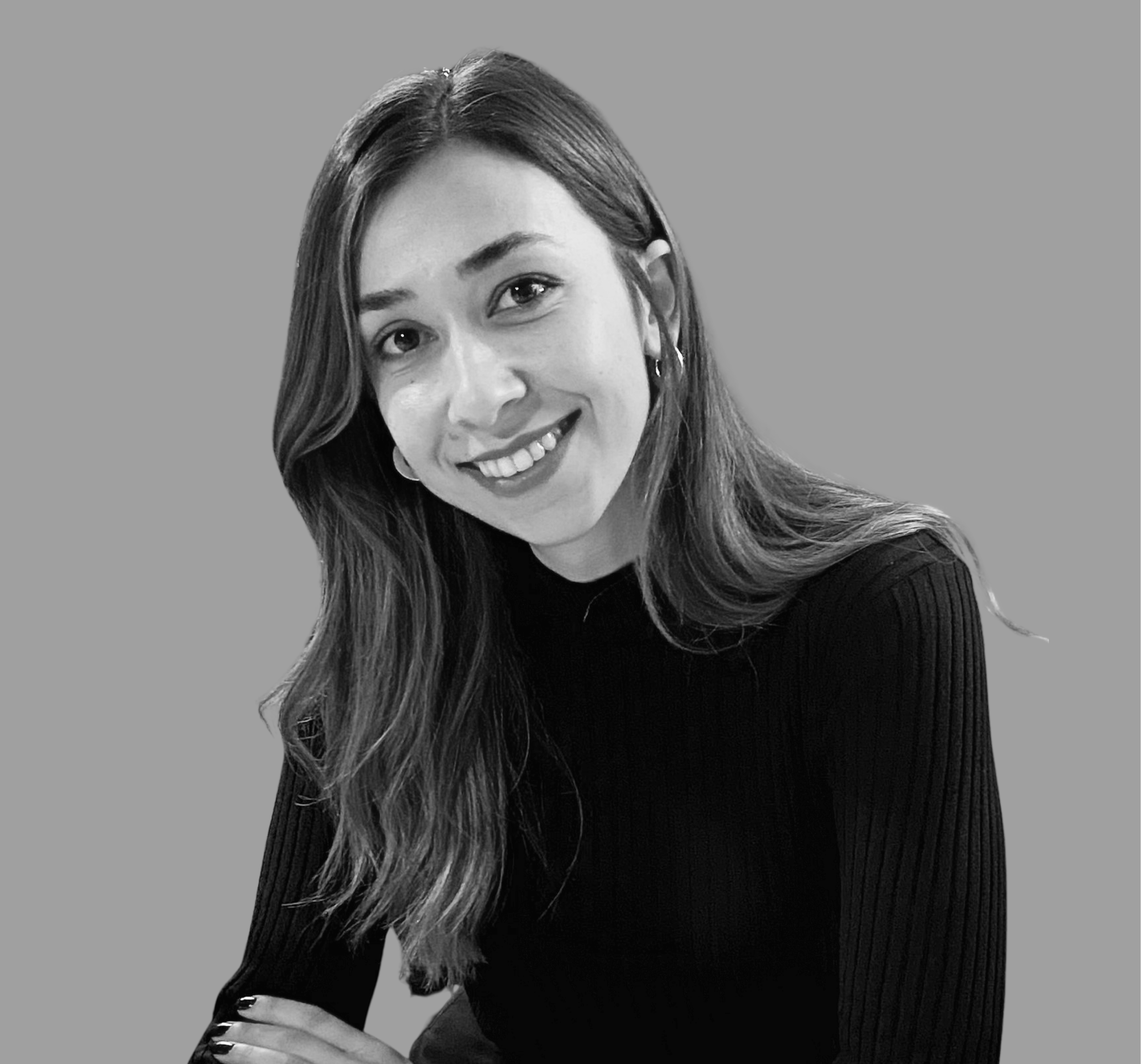 Black and white portrait of a smiling woman with long wavy hair, wearing a black top, against a plain background.