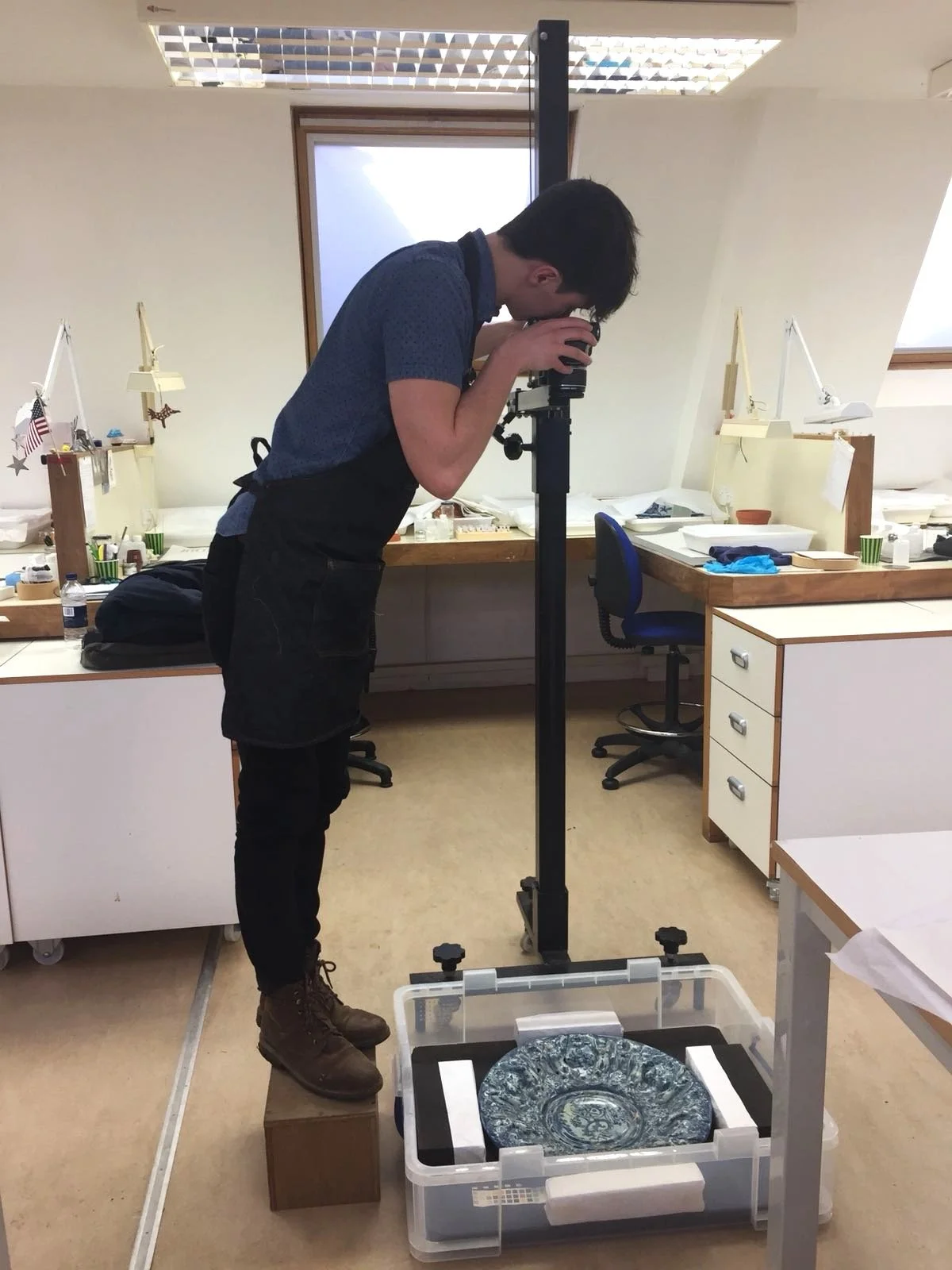 Photographing a ceramic maiolica plate for museum-quality ceramic conservation or restoration treatment; pottery restoration; photography and documentation. Glazed earthenware plate being restored by a ceramics conservator in San Francisco Bay Area.