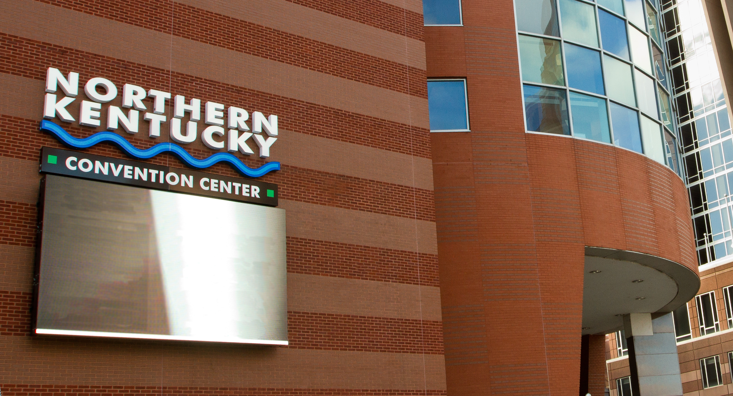 Exterior of the Northern Kentucky Convention Center with a sign reading 'Northern Kentucky' and a digital board below.