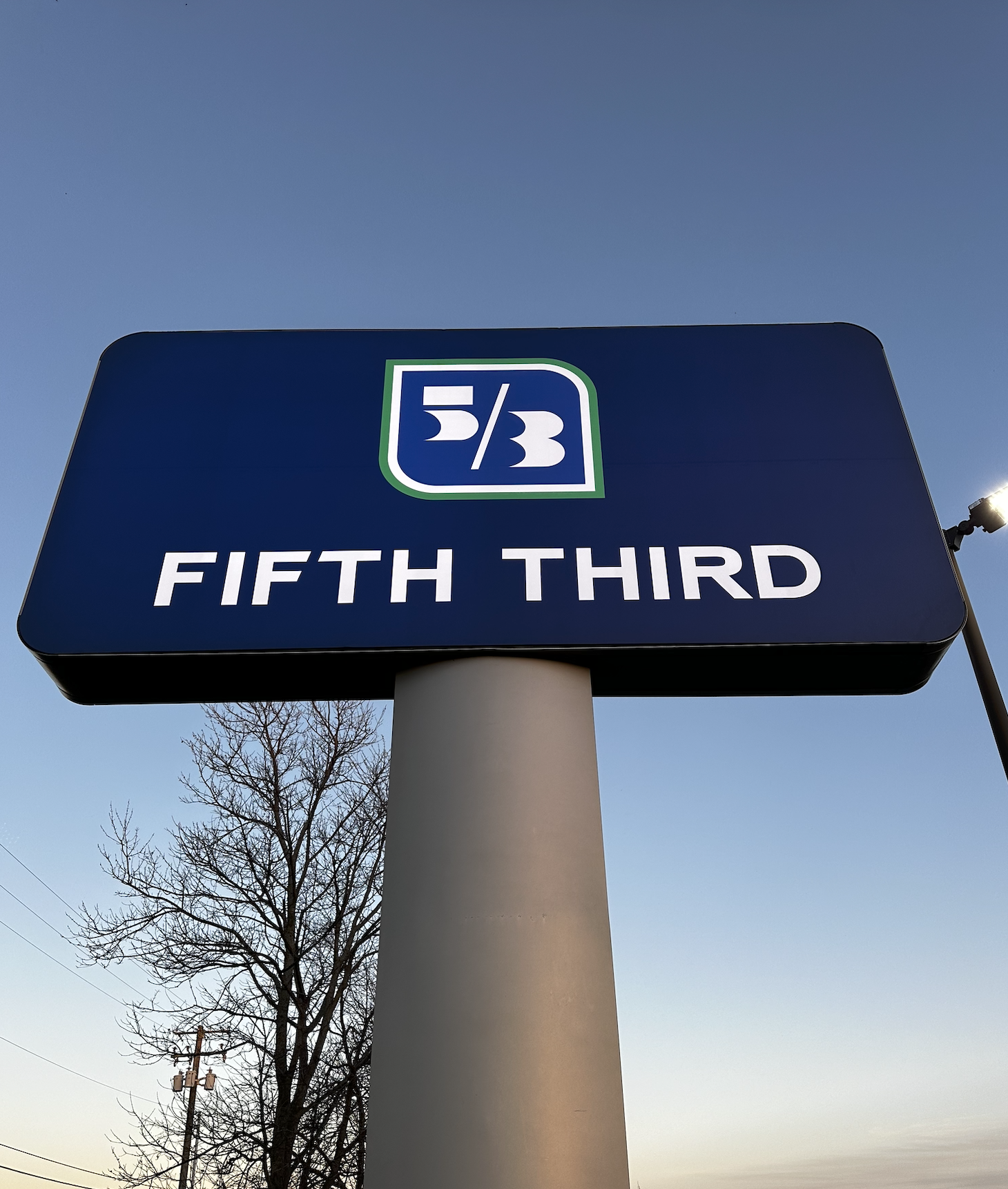 Pylon sign installation at a Fifth Third Bank in Kentucky at sunset.