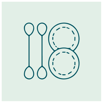Two spoons and two paper plates arranged on a light green background.