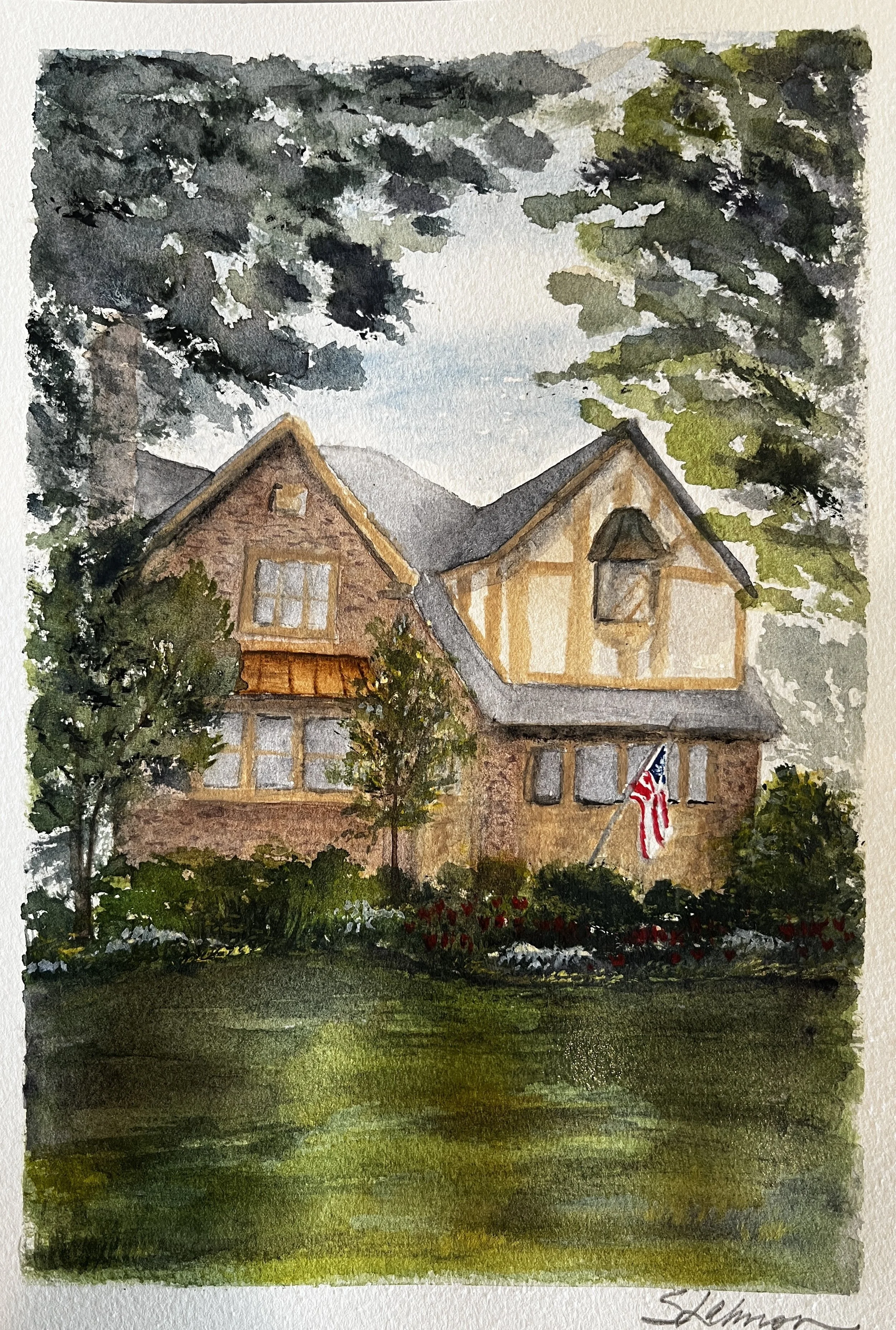 Watercolor painting of a two-story brick house with a steep roof, surrounded by tall green trees and a garden with flowers, American flag displayed outside, under a cloudy sky.