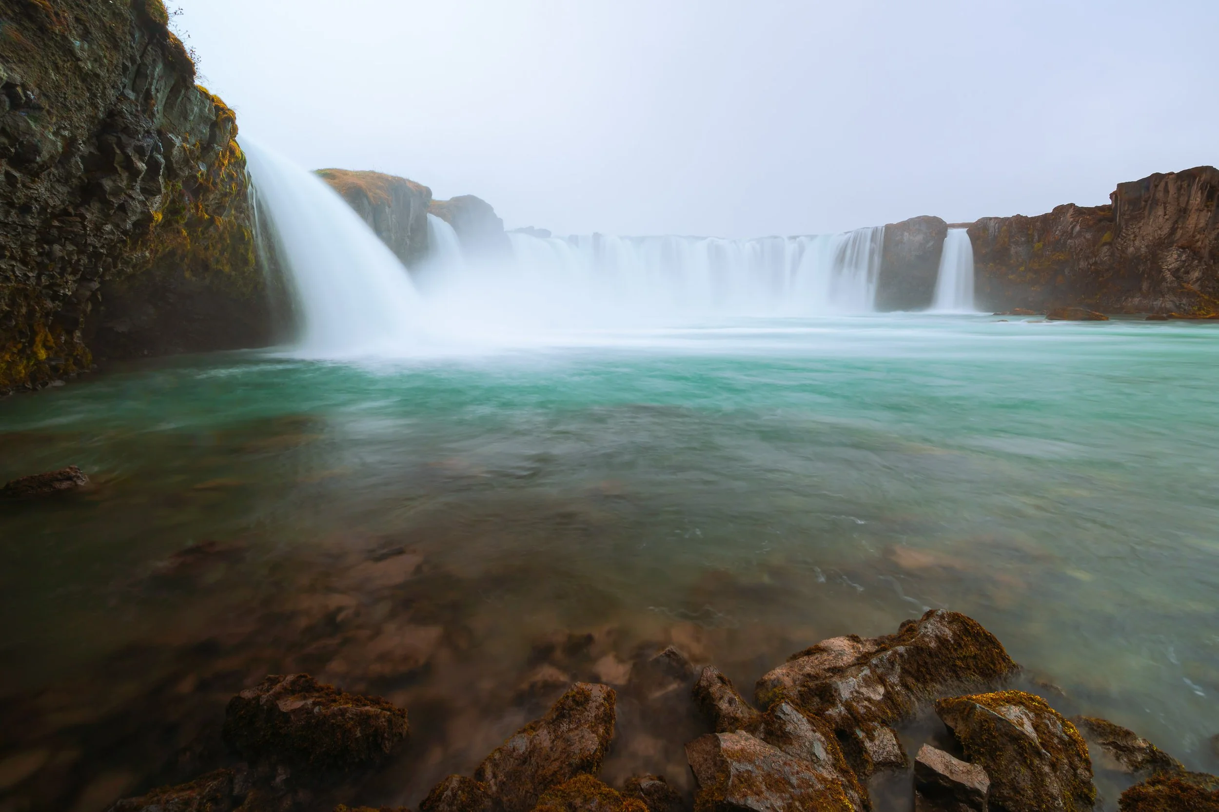 Northern Fold

Goðafoss waterfall in northern Iceland with wide cascading falls flowing into a turquoise glacial river, viewed from rocky foreground.