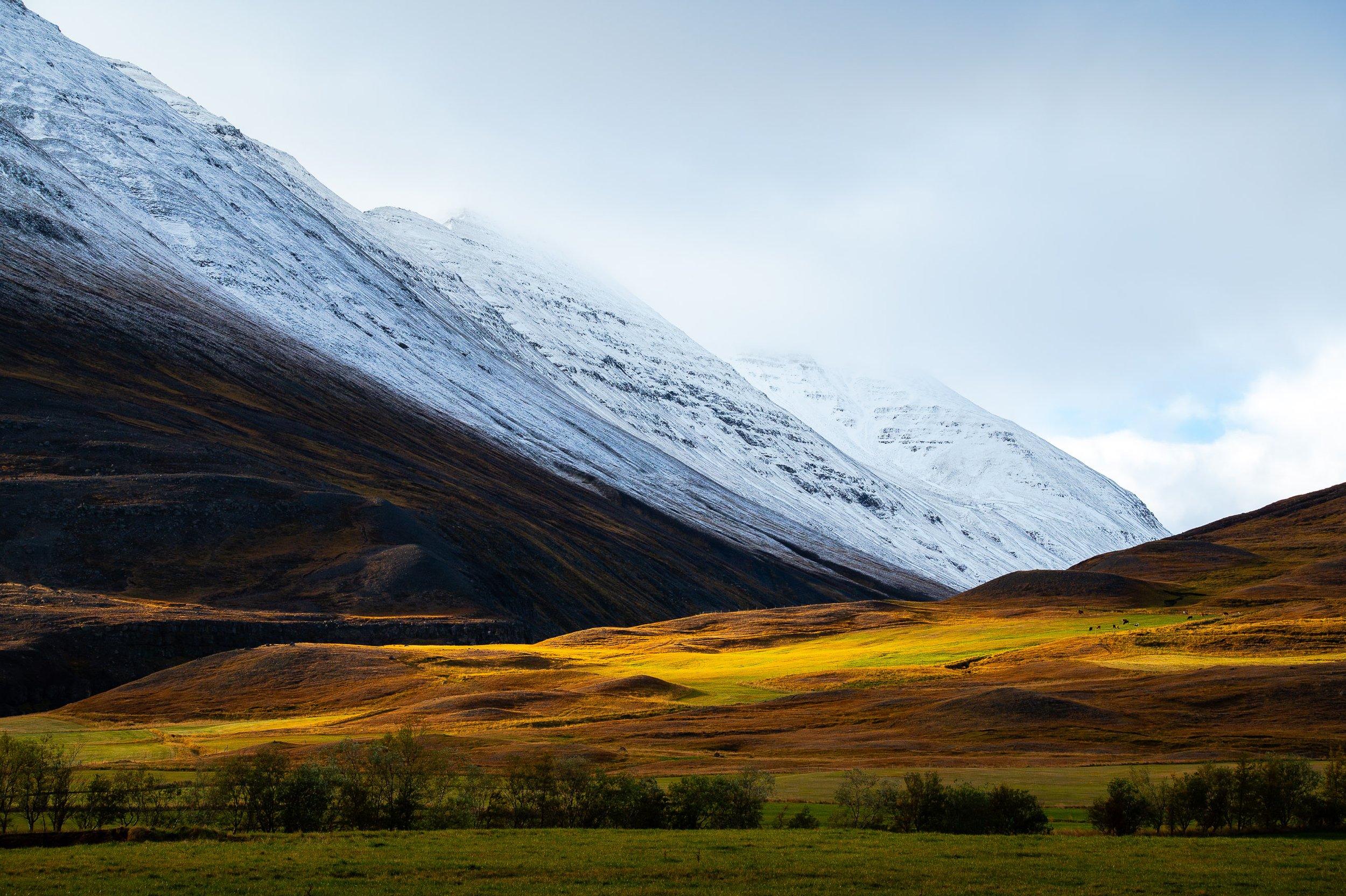 Touch of Light

Snow-covered mountains rising above rolling brown and green hills in northern Iceland, with a bright patch of sunlight illuminating the valley.
