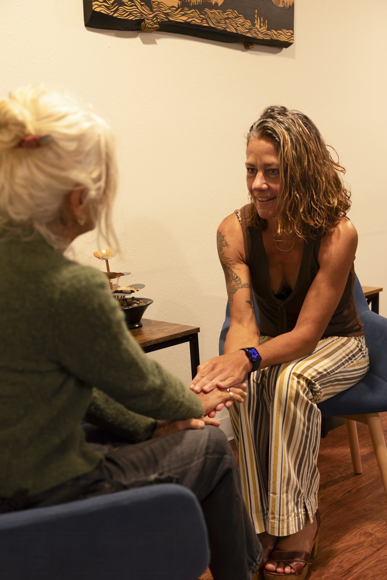 Image showing Dr. Carrie Decker holding her patients hand while she discusses her health concerns.
