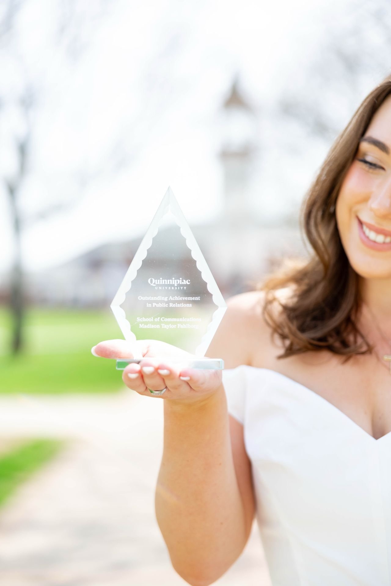Individual holds up a crystal award.
