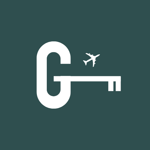 A white key with a large letter G on it, with an airplane icon above the key's head, on a dark green background.
