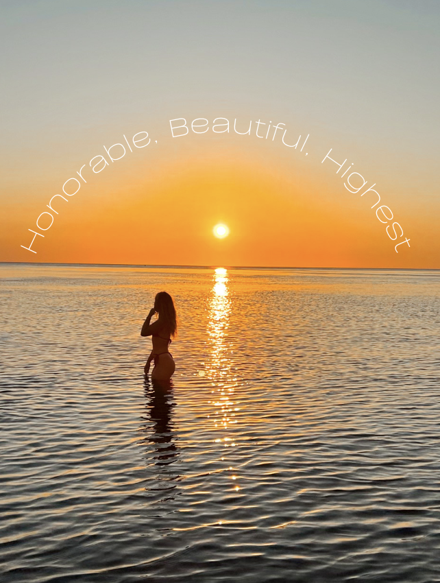 A silhouette of a woman standing waist-deep in water at sunset, with the sun near the horizon reflecting on the water. The sky is clear, and the scene is calm and picturesque. The text "Honorable, Beautiful, Honest" is curved across the sky.