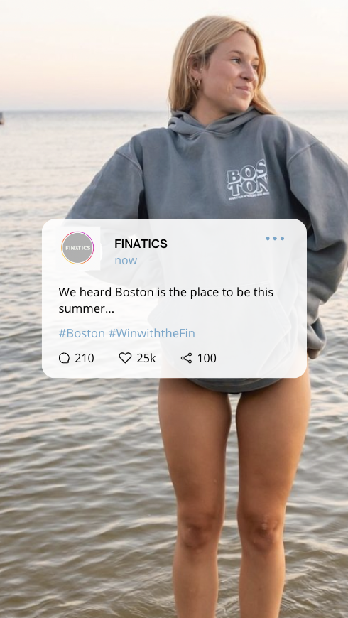 A woman standing in the water at the beach, wearing a gray hoodie and no pants, with a social media post overlayed about Boston.