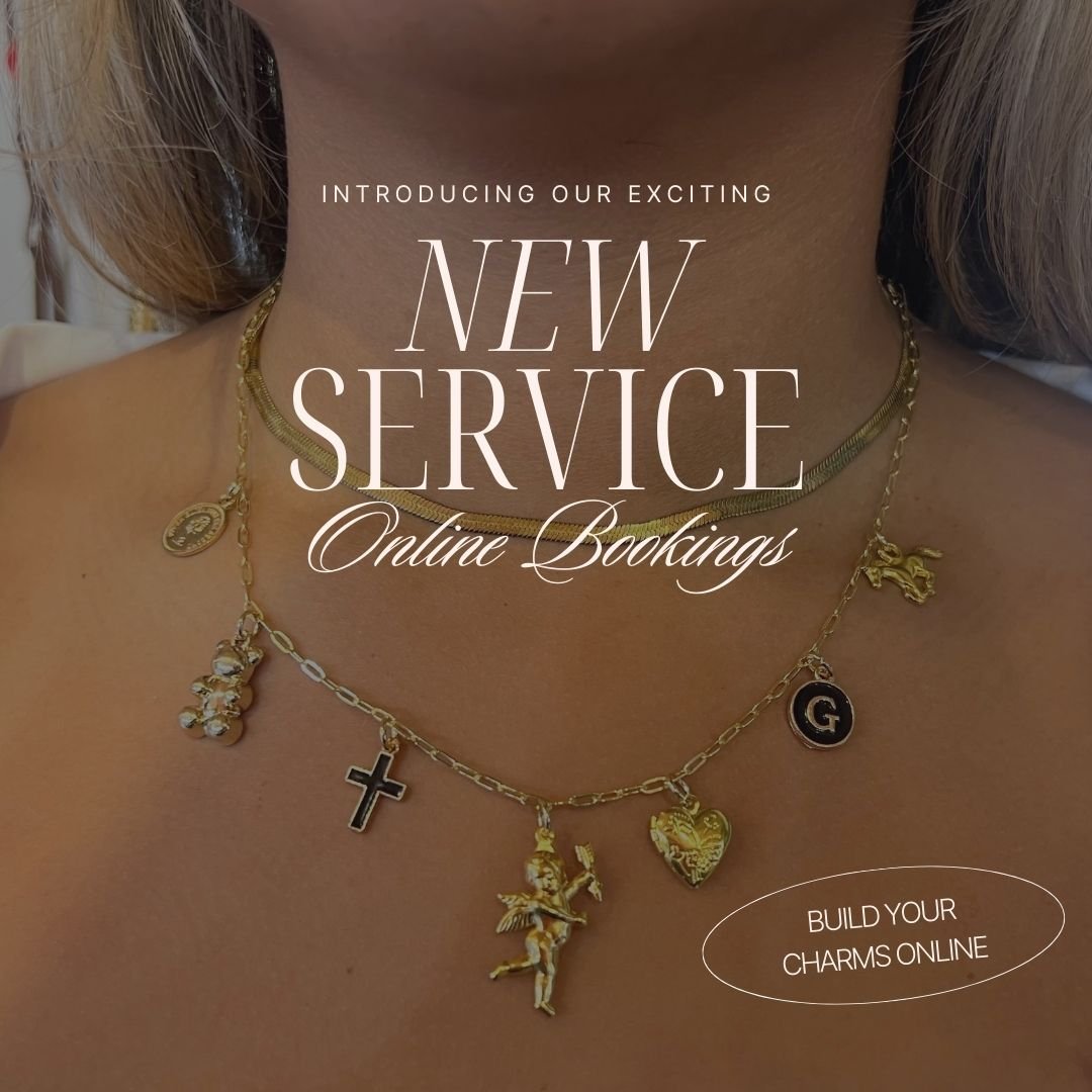 Close-up of a woman's neck wearing a gold charm necklace with various dangling charms including a cross, angel, and heart, with promotional text advertising new online booking service and charm building website.