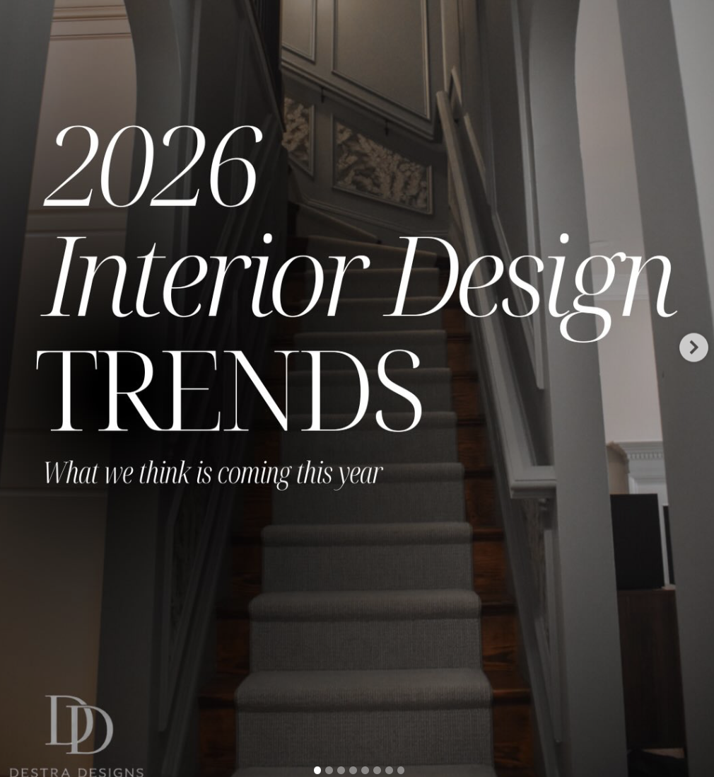 Cover image for interior design trends 2026 article showing a staircase with a gray carpet runner, white walls, and decorative wall panels.
