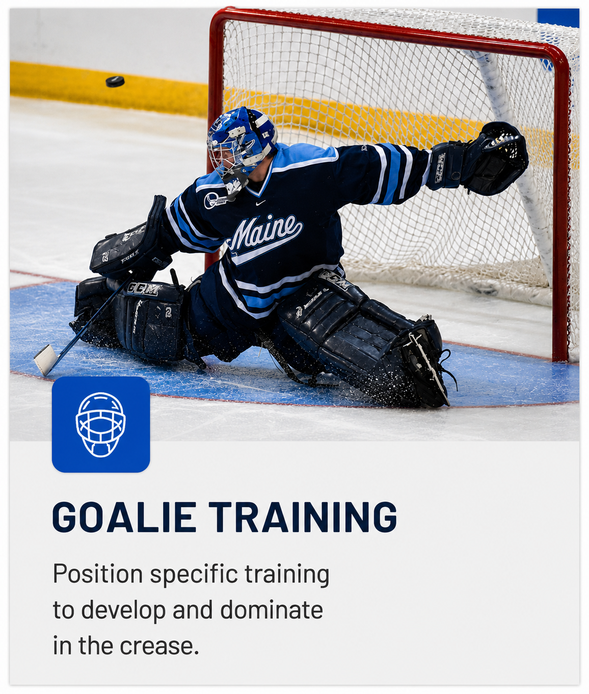 A hockey goalie in a blue Maine jersey and black gear makes a save on the ice, in front of a net.