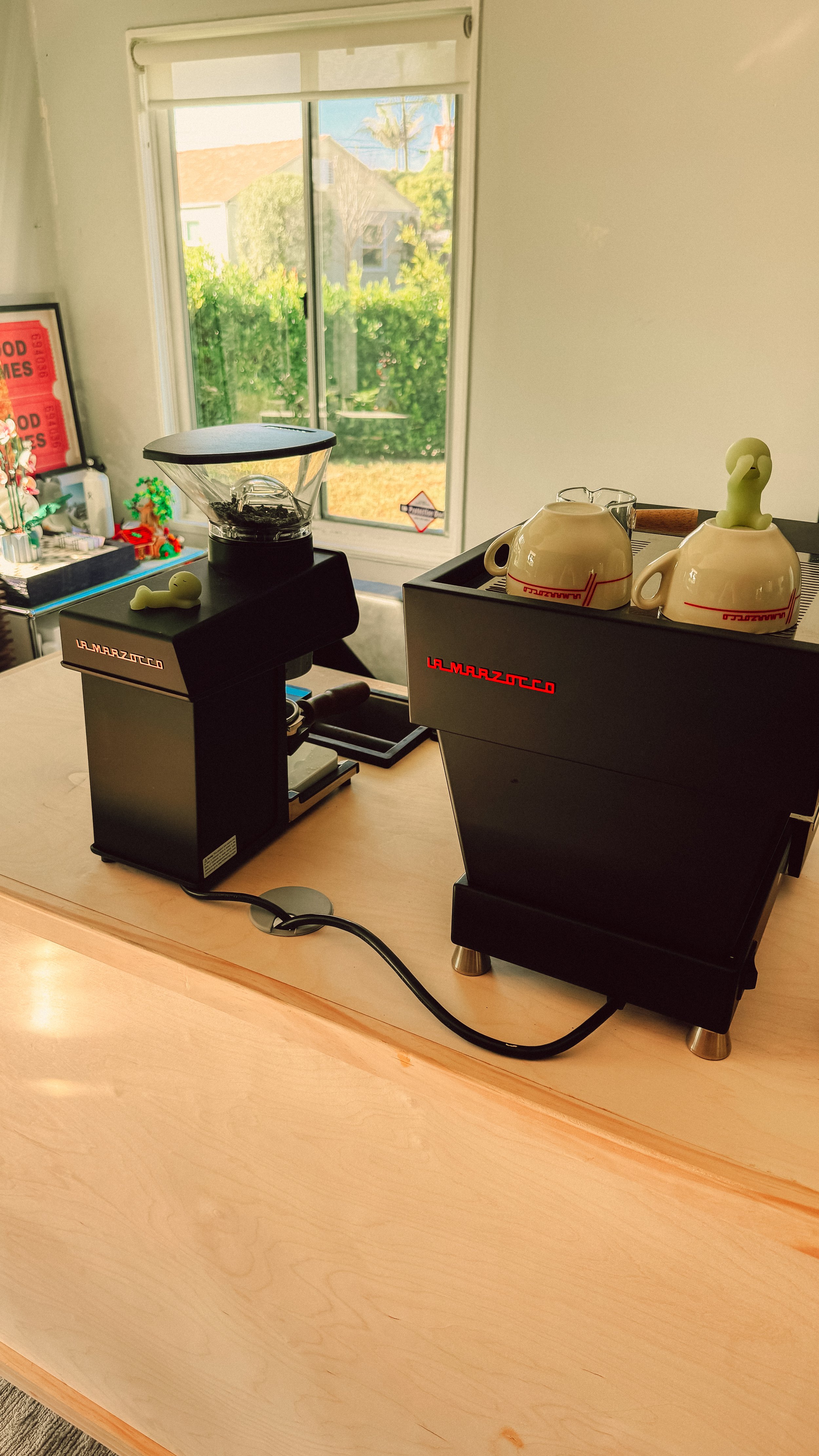 Dialed’s espresso machine and grinder on a sunlit wooden coffee bar.