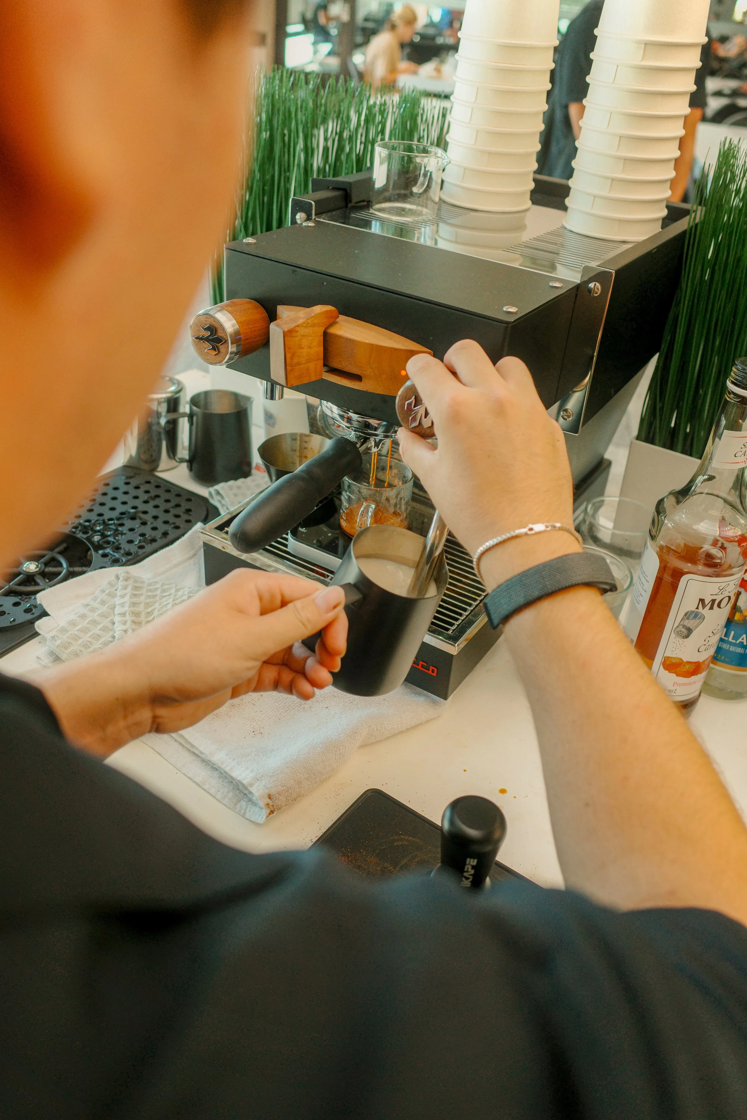 A Dialed barista pulling espresso and steaming milk at the coffee cart.