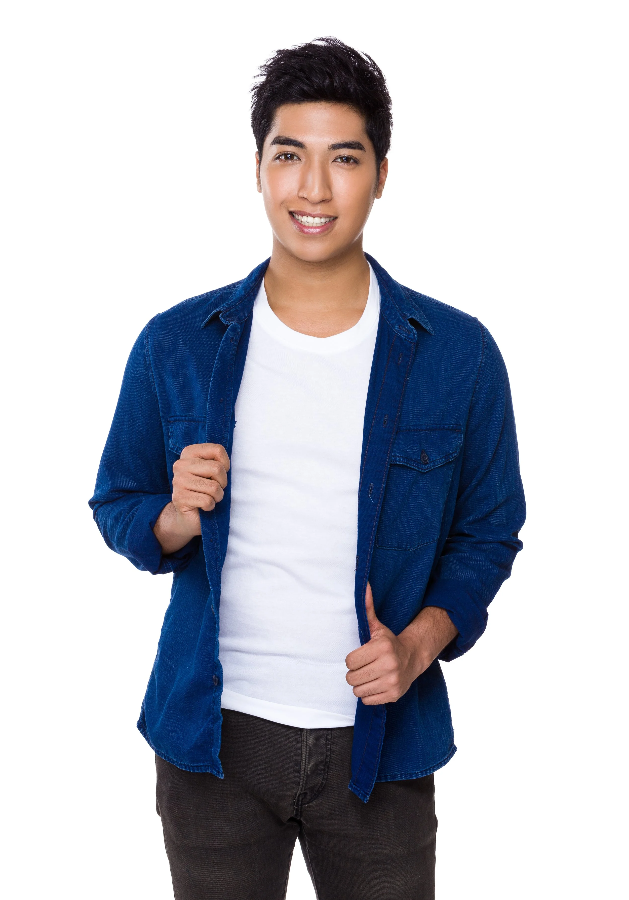 A young man smiling, wearing a white t-shirt and a blue denim shirt, holding the lapel of his denim shirt with one hand, standing against a white background.