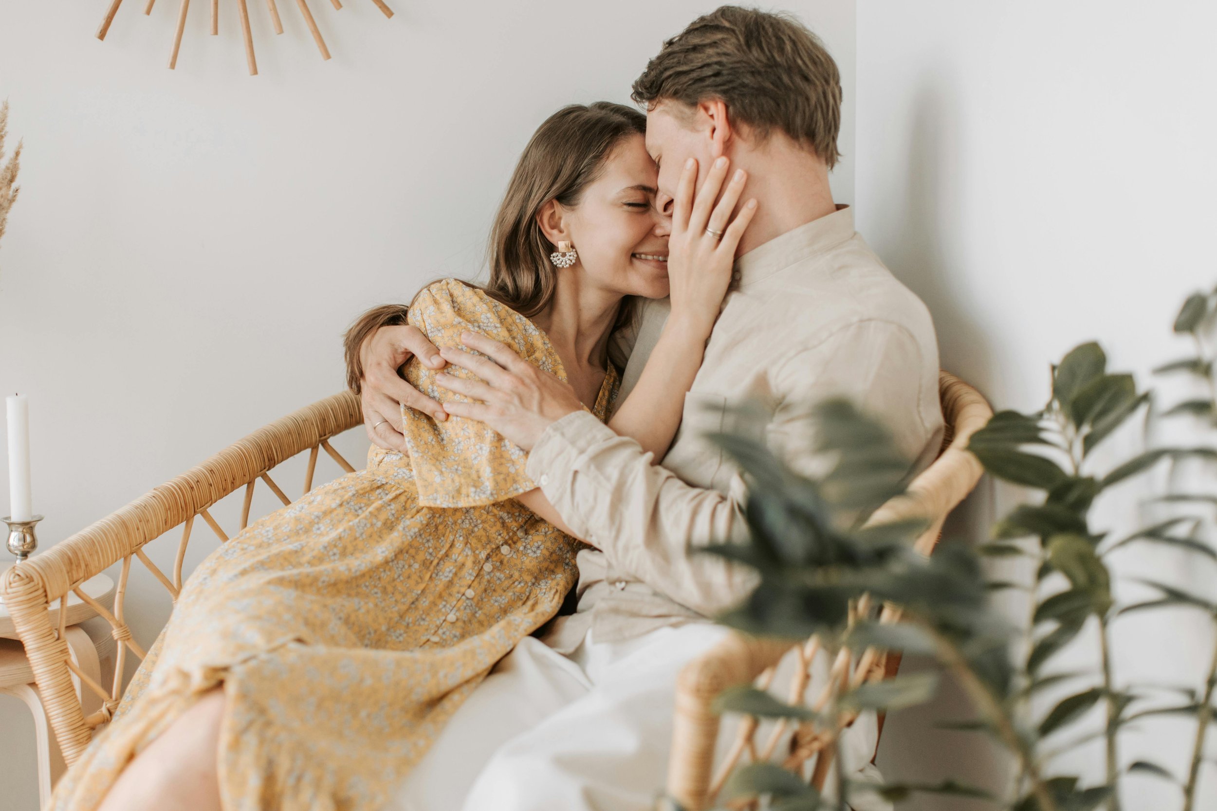 A couple smiling and embracing each other happily in a cozy indoor setting.