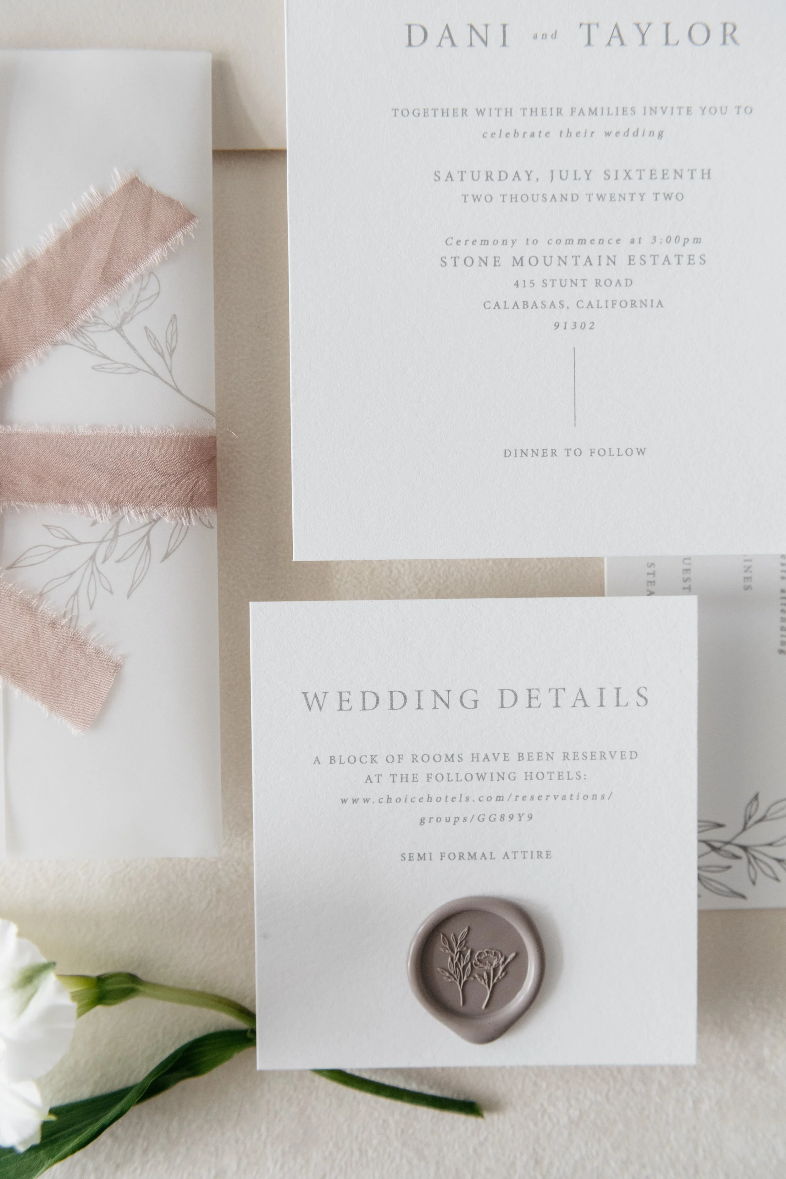 Elegant wedding invitation suite with floral design, featuring RSVP card, details card with wax seal, and pink ribbon on vellum paper. Malibu, California