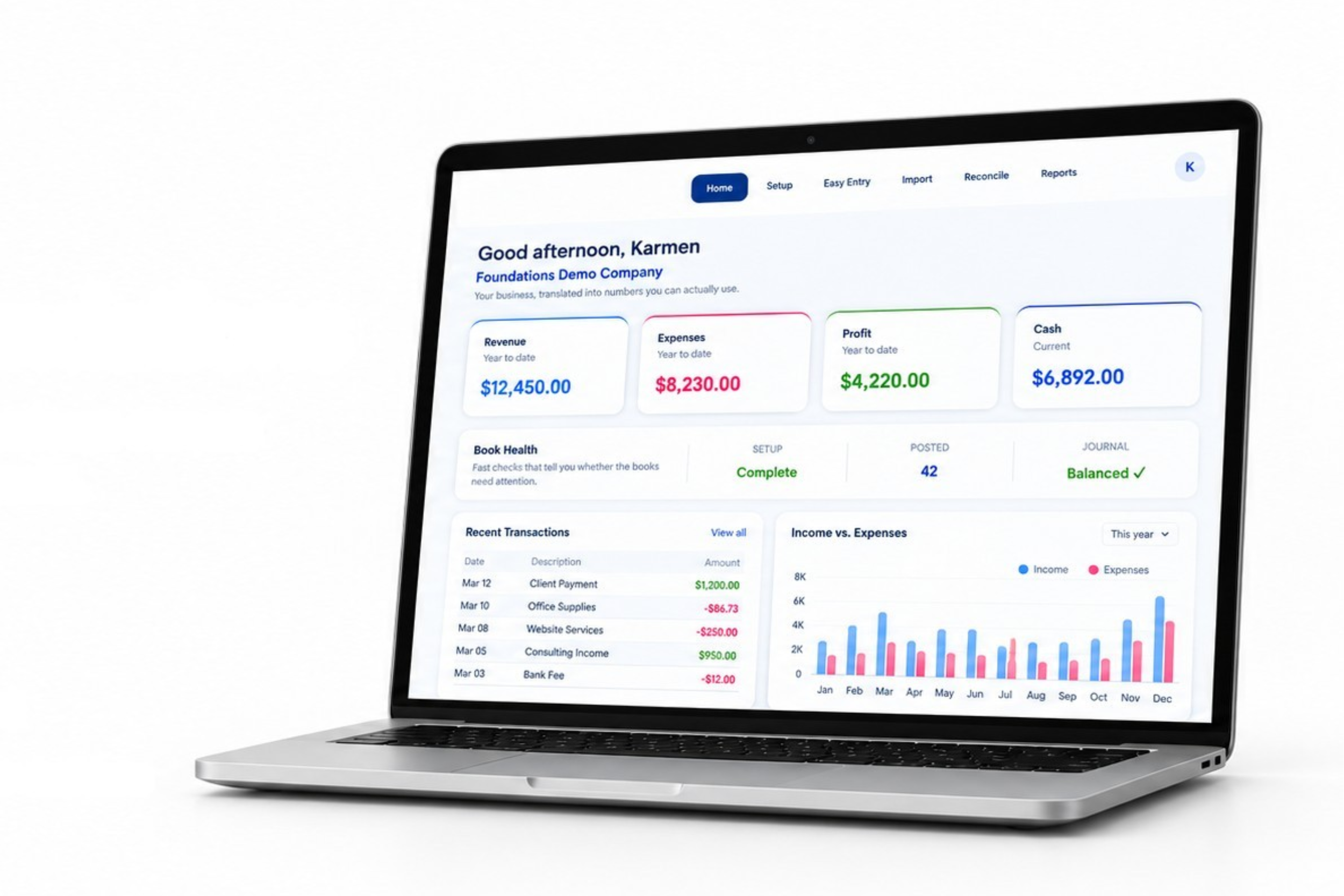 Laptop displaying the Own Your Bookkeeping Foundations dashboard with tools for transactions, reconciliation, reports, and book health.