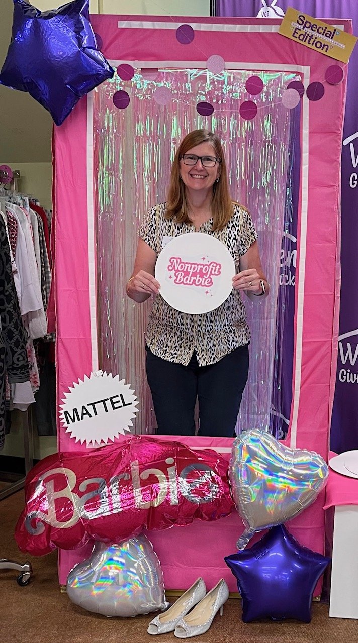 Lisa in a lifesize Barbie box, holding a sign that says Nonprofit Barbie
