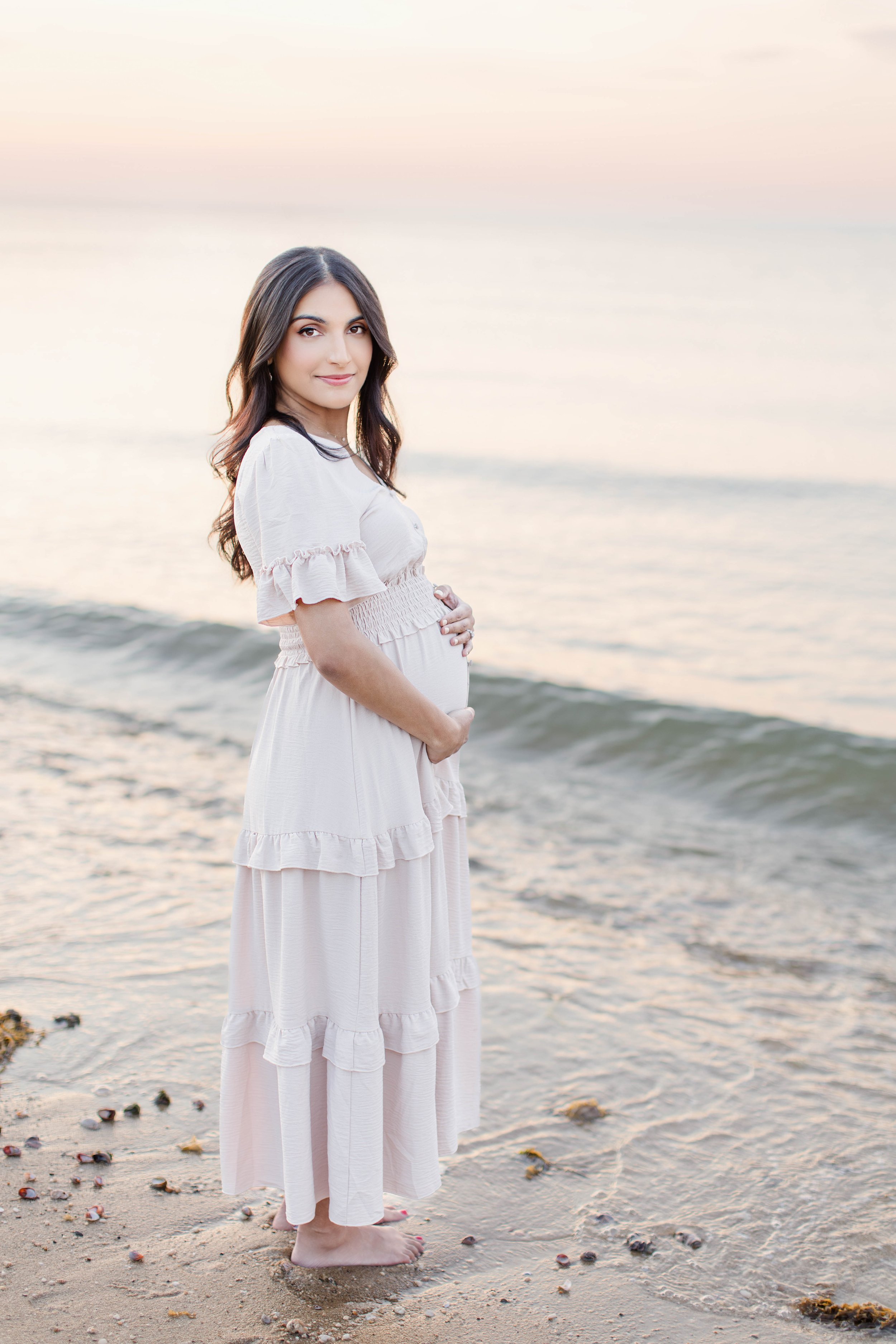 Expecting mother in a flowing dress during a sunset maternity photography session at Sunken Meadow State Park on Long Island