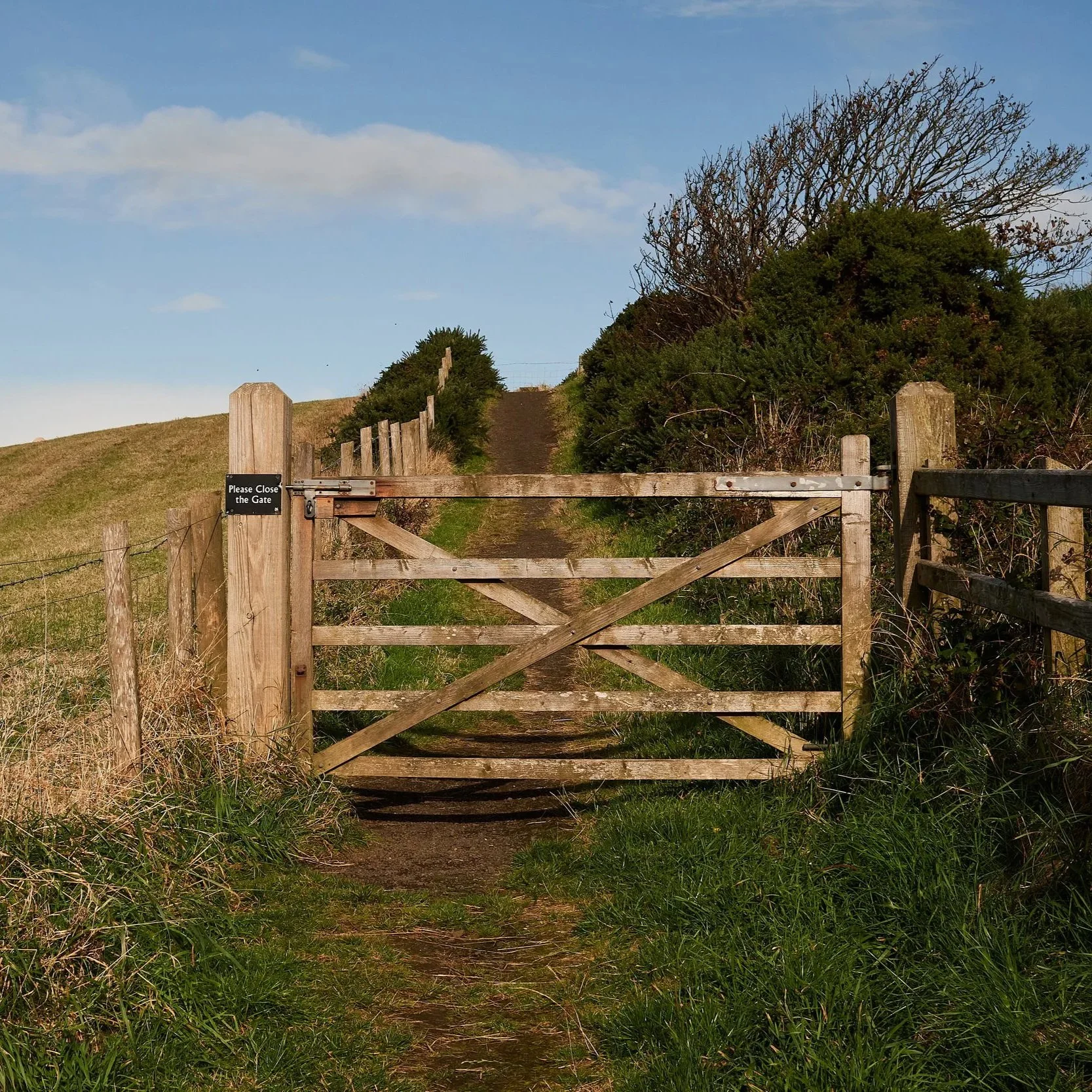 Timber countryside access gate feature beside a rural public rights of way footpath