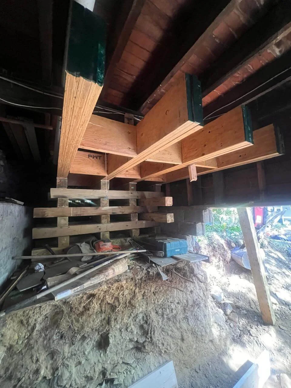 Opened up to daylight. New beams and cribbing hold everything above while the ground below is dug out.
