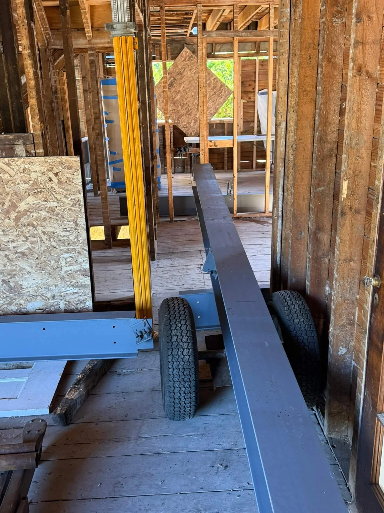 One beam at a time, with the structure fully supported around it.