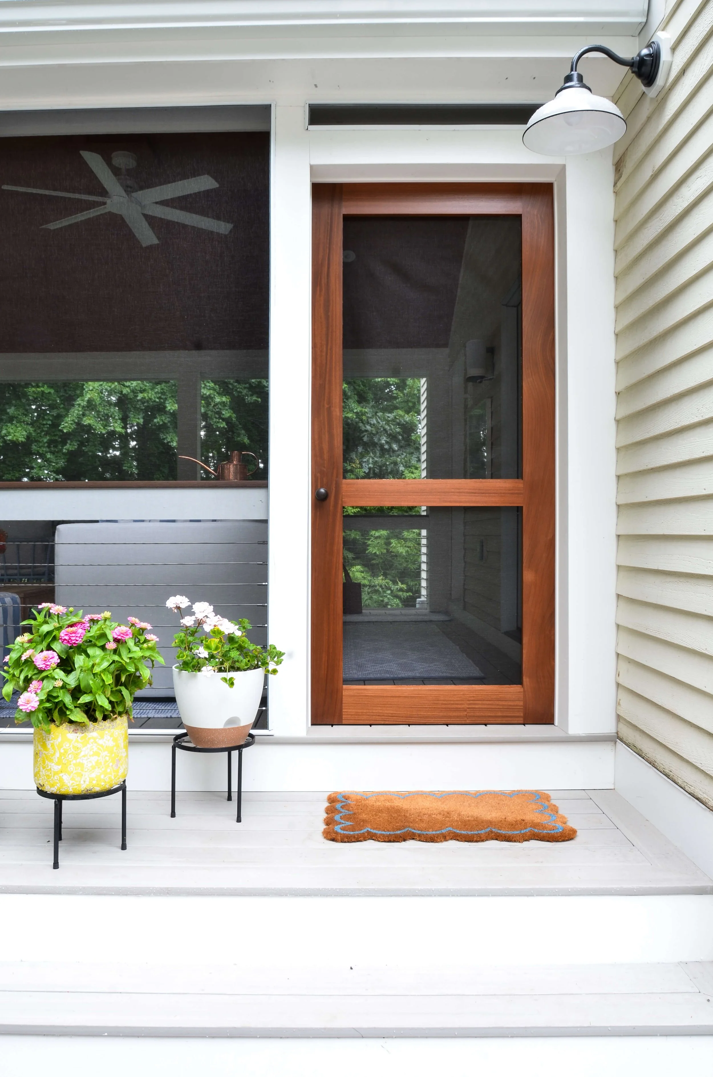 The entry sets the tone: a stained wood screen door, framed in clean white trim.