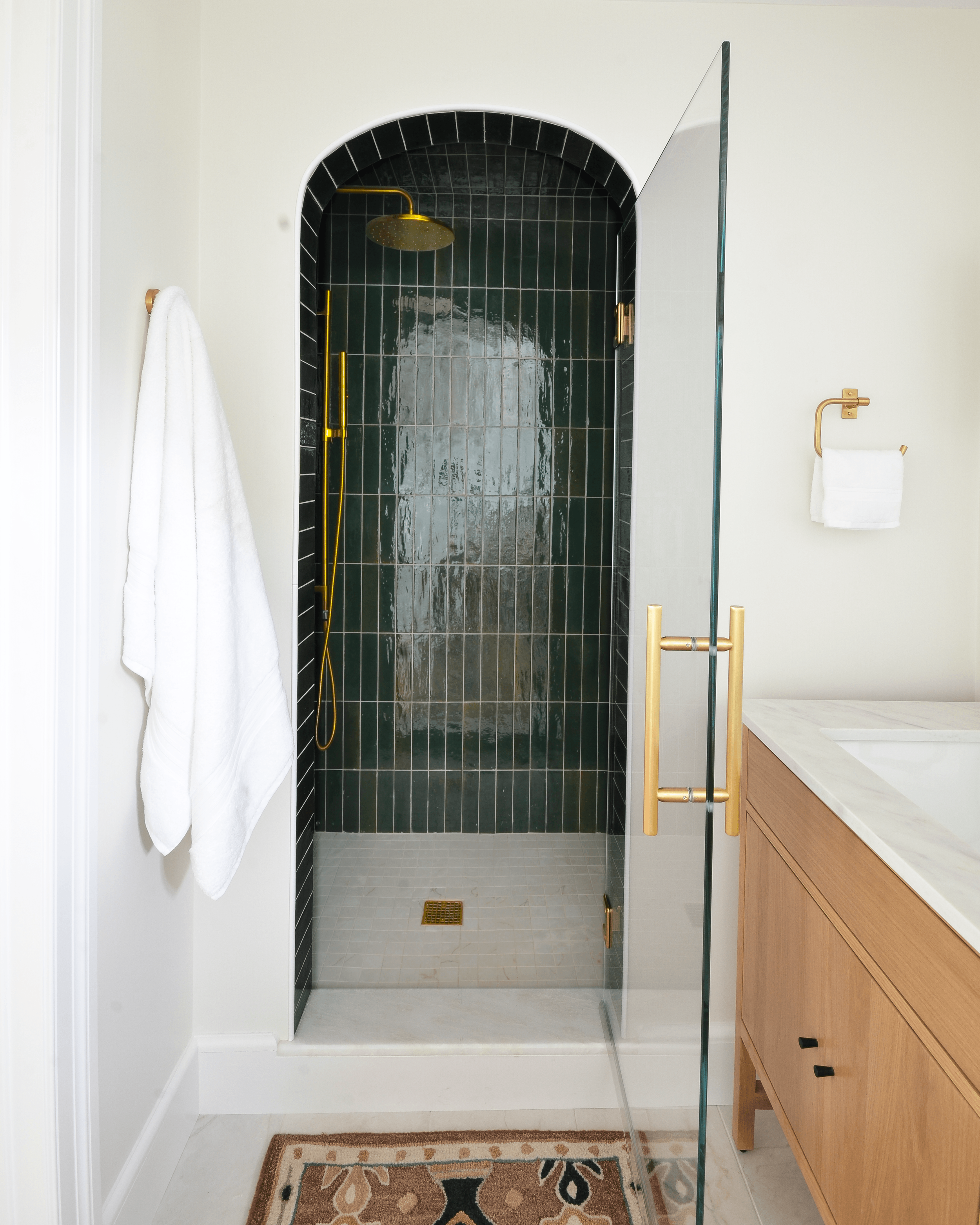 A rounded archway frames the shower in dark, moody tones - cavernous, spa-like, and fully intentional.