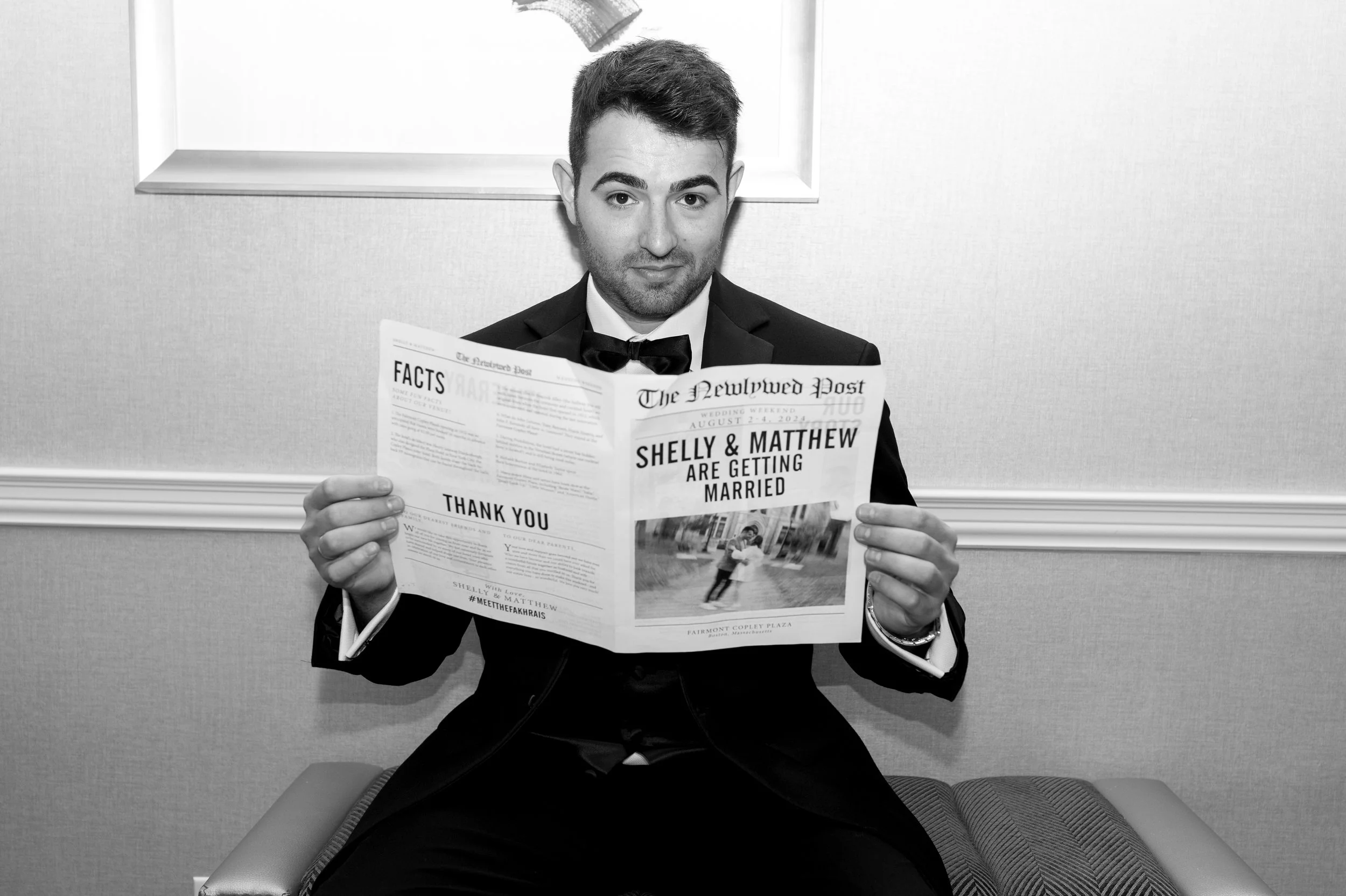 A man in a tuxedo sitting on a bench, reading a newspaper with a headline announcing his marriage to Shelly, in a grayscale photo.