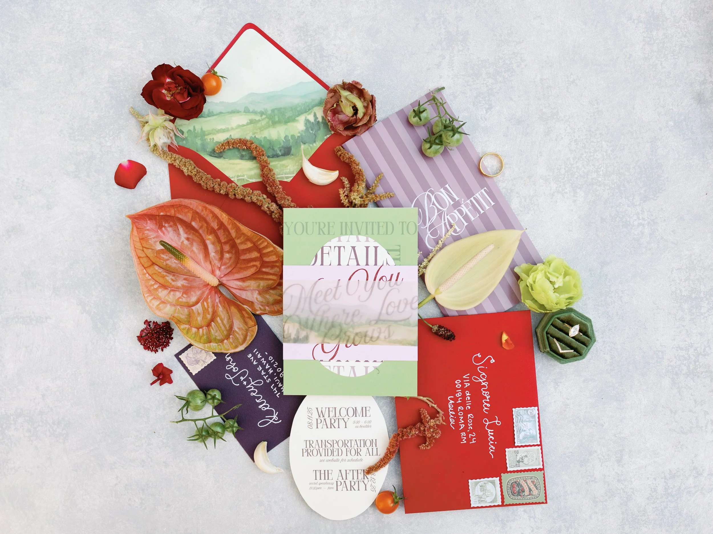 A collection of colorful invitation cards, flowers, and decorative items arranged on a light background for a special event or celebration.