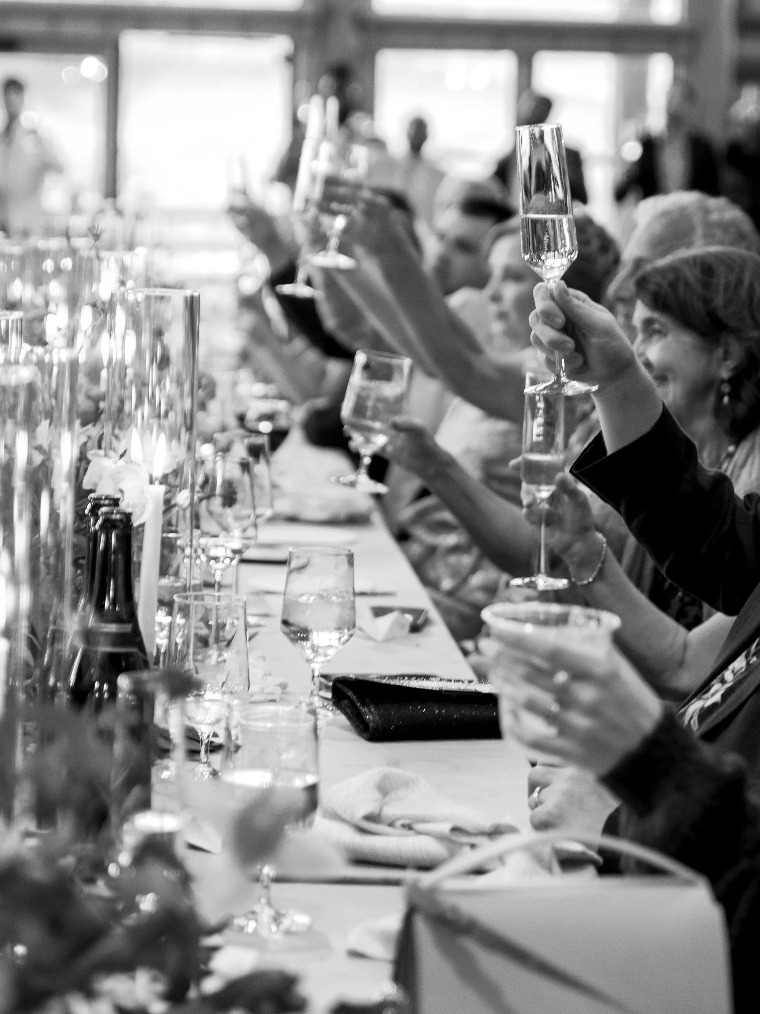 People raising glasses of champagne in a toast at a celebration or gathering.