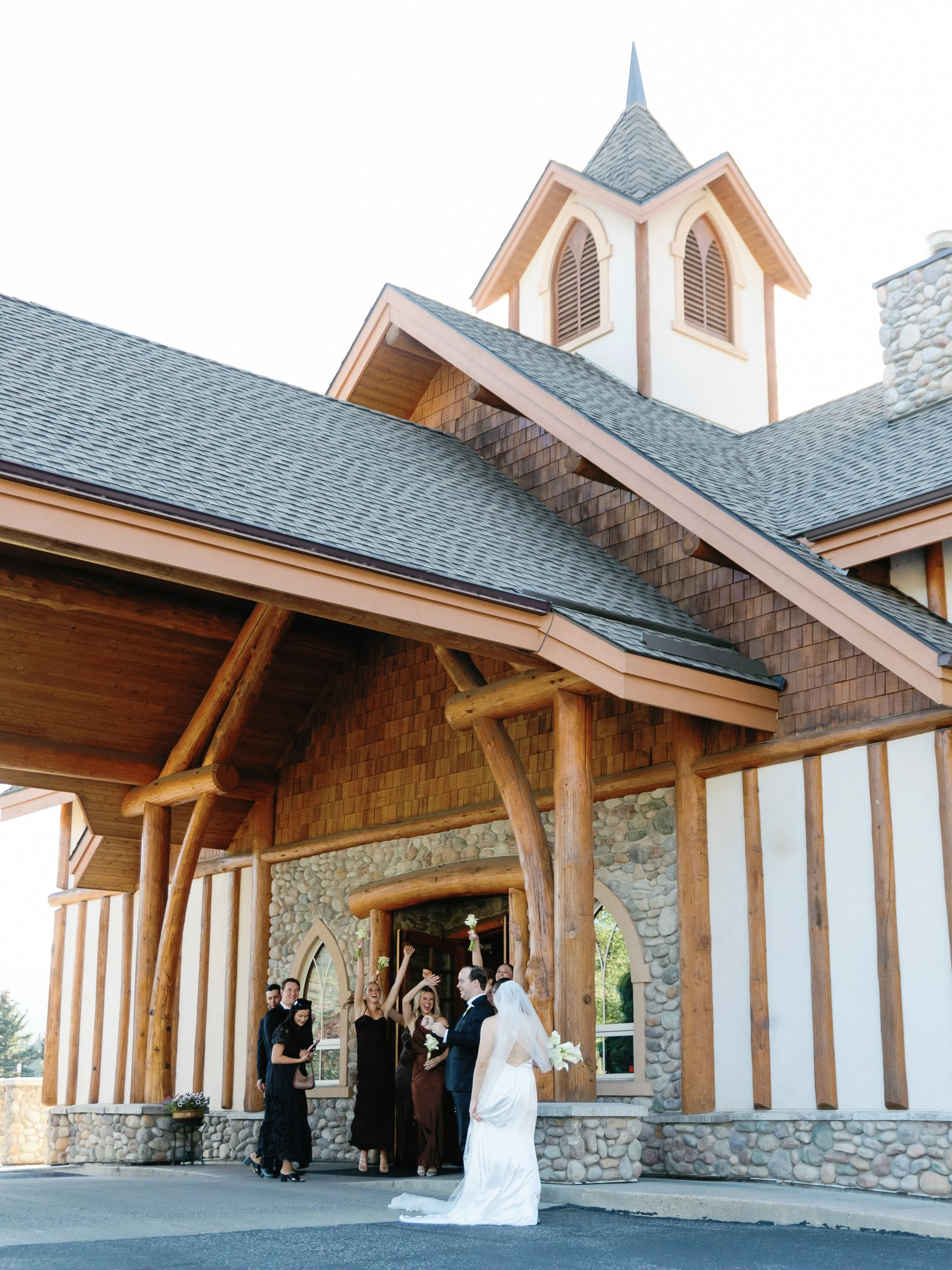 Wedding celebration outside a church with a bride in a white gown and a group of people celebrating