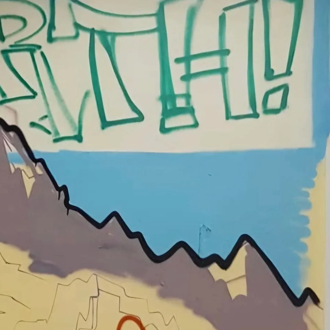 Colourful graffiti on a wall with abstract shapes and bold outlines, featuring green, blue, yellow, gray, and black colors.