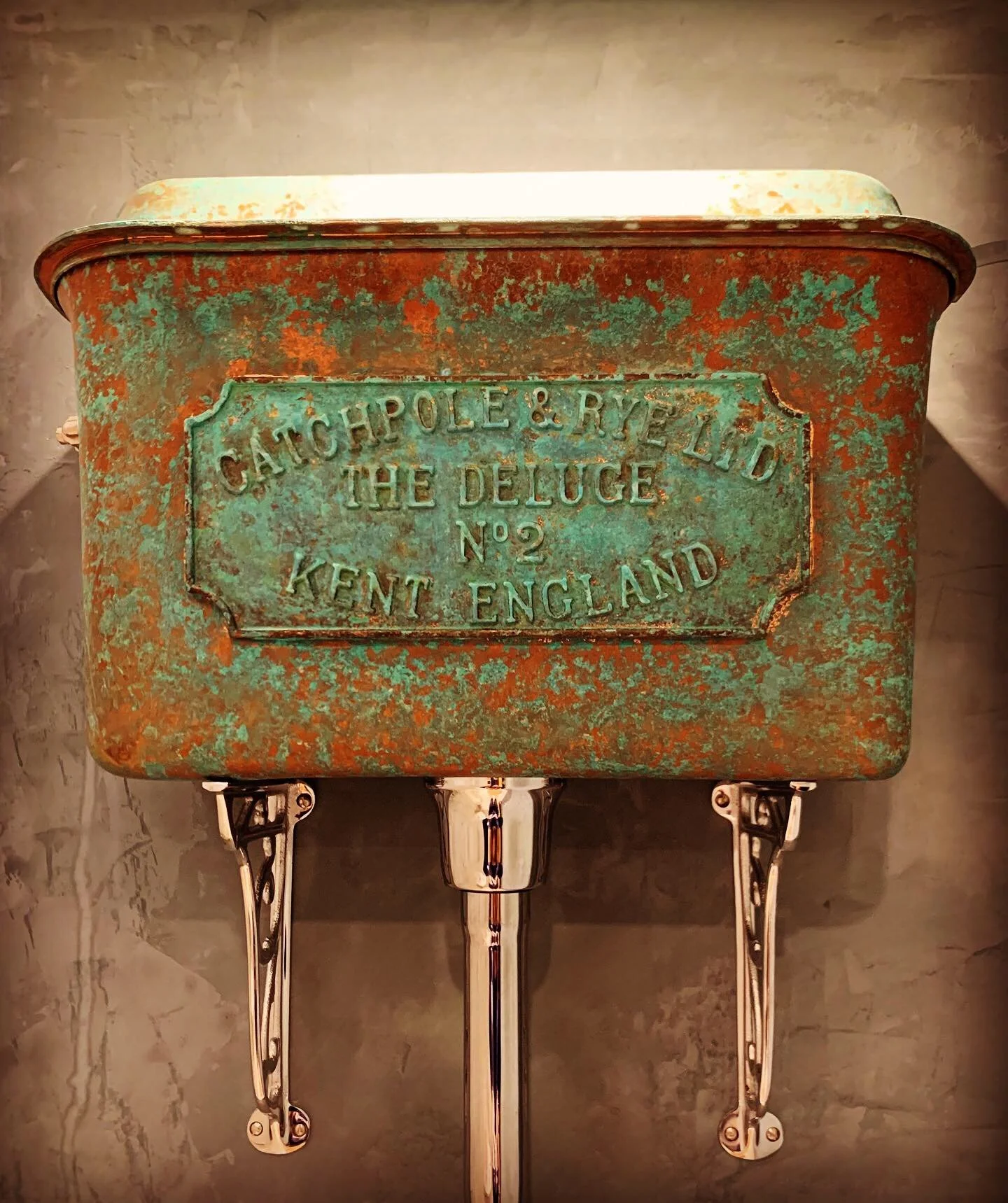 Catchpole & Rye traditional high-level chain-pull toilet cistern with aged copper patina and polished fittings in a luxury bathroom renovation