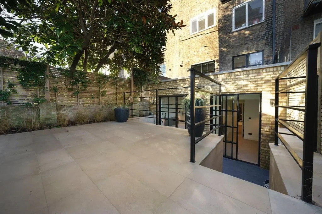 Notting Hill home extension with Crittall-style doors, brickwork, composite roof terrace, stone copings and landscaped patio area